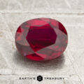 A 1.29-carat Mozambique Ruby (heated), faceted in an oval shape, rests on a textured silver surface, with the Earth’s Treasury logo and text below.
