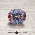 A 1.61-carat purple-orange particolored Montana sapphire (heated) with striking blue and orange hues rests on a textured metallic surface, while the “EARTH’S TREASURY” logo and text appear at the bottom.