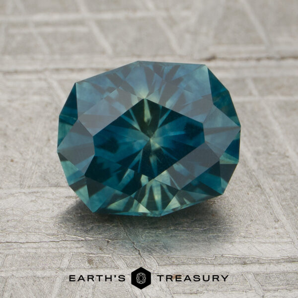 1.95-Carat Peacock-Yellow Particolored Montana Sapphire (Heated) A 1.95-carat peacock-yellow particolored Montana sapphire (heated) with an octagonal cut is displayed on a textured gray surface, with the “EARTH’S TREASURY” logo and text at the bottom of the image.