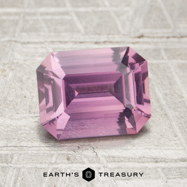 2.08-Carat Pink Ceylon Sapphire (Heated) A 2.08-carat pink sapphire, cut in a rectangular faceted shape, is displayed on a textured light surface with the text “EARTH’S TREASURY” at the bottom.